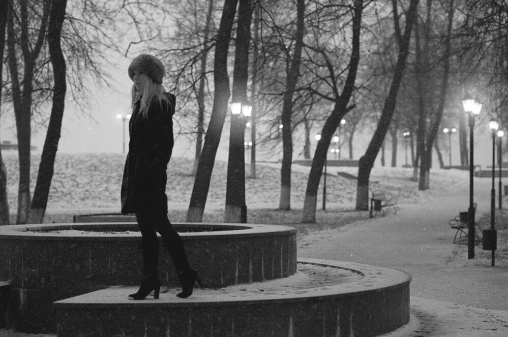 Фонарь на улице, сквозь снег летящий щурится...