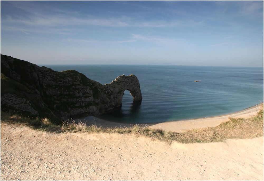 Durdle Door.
Каменная арка чем-то напоминает животного на водопое. Как и Lulworth Cove является популярнейшим драмматическим объектом для пейзажистов в часы восхода и заката.