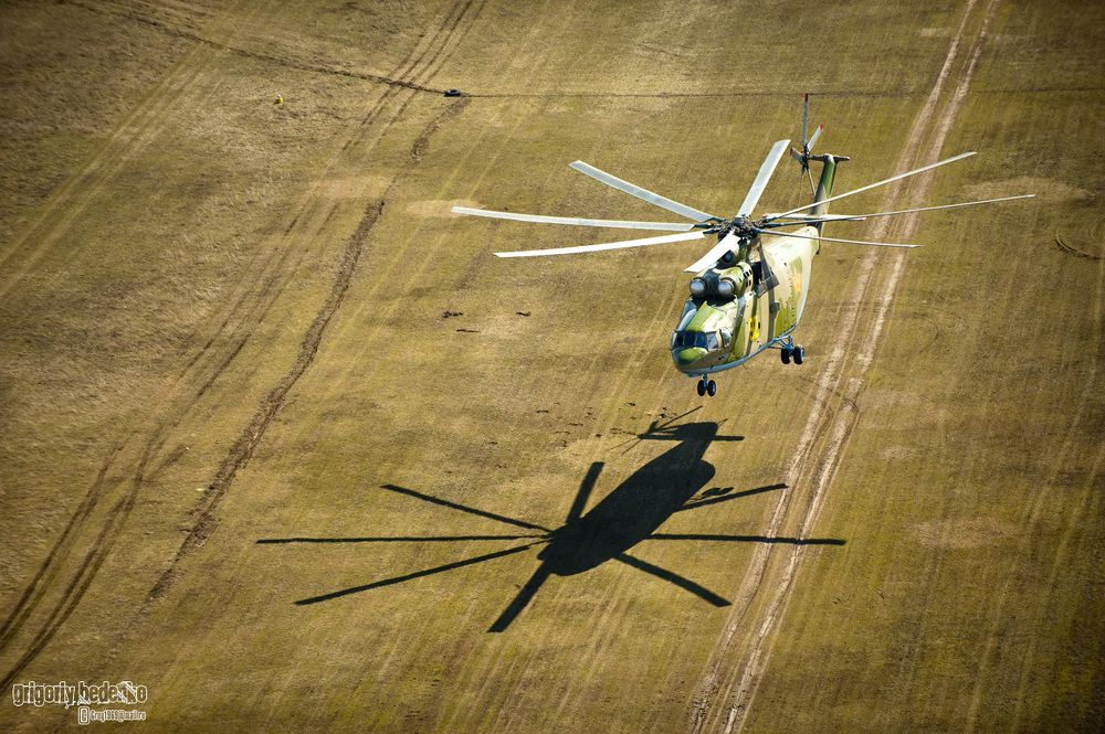 Мы попросили экипаж &ldquo;Ми-26&rdquo; зависнуть на 10-метровой высоте. Тем временем командир авиабазы сделал на UH-2 несколько кругов над гигантом. Получился очень эффектный снимок с контрастной тенью на земле.