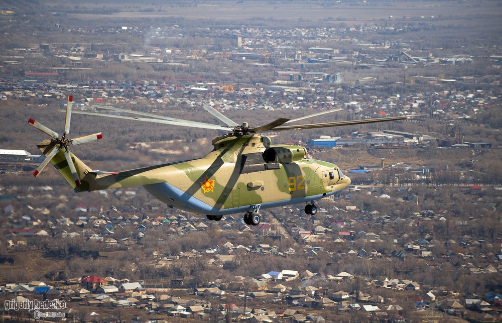 Cегодня гигантский вертолет, кроме России эксплуатируют еще 12 стран мира, причем и в гражданском и в военном секторе. Всего было построено 310 машин, из них на момент развала Советского Союза в Казахстане оставалось 24 вертолета. Однако в 90-е годы они выработали свой ресурс и встали на прикол. Стоимость одной машины оценивается в 25 миллионов долларов, и частичное восстановление казахстанского авиапарка стало возможно лишь сейчас, когда выполняется специальная программа по технической модернизации армии. Первый модернизированный &ldquo;Ми-26&rdquo; с бортовым номером &ldquo;91&rdquo; поступил на вооружение 3 года назад. Экипаж этого &ldquo;Ми-26&rdquo; состоит из 5-ти человек, а когда необходимо обслуживать специальное водосливное устройство для тушения пожаров, на борт поднимается еще один специалист &ndash; бортовой оператор. Вертолет может поднять сразу 15 тонн воды. Скорость &ldquo;Ми-26&rdquo; 295 километров в час, а дальность полета с тремя дополнительными баками почти две тысячи километров. Таким образом, машина может взять на борт 82 десантника с полным вооружением и перебросить их с одного конца Казахстана на другой. Это незаменимая транспортная система, когда речь идет о бескрайних казахстанских степях. Также для &ldquo;Ми-26&rdquo; достижима любая площадка в горной местности, куда невозможно добраться наземным транспортом.