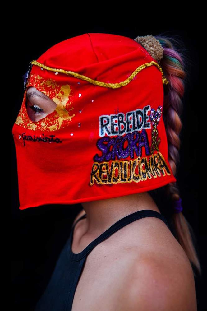 Baila Capucha Collective&rdquo;   Women from the &ldquo;Baila Capucha&rdquo; Collective pose with their red hoods to protect their identity due to fear of being imprisoned, discriminated or fired from work for participating in the protests held in the context of the social revolt against the neoliberal economic system and the government of Sebasti&aacute;n Pi&ntilde;era in Chile.  The Baila Capucha is a group of dissidents, self-organized women that dance with their faces covered by bright red and black hoods in order to remain anonymous and protect members while they express themselves by way of dance.  The feminist collectives in the protests of the social revolt played different roles. In addition to being at the heart of the changes demanded by women in terms of justice and work conditions, they also play a leading role in society.