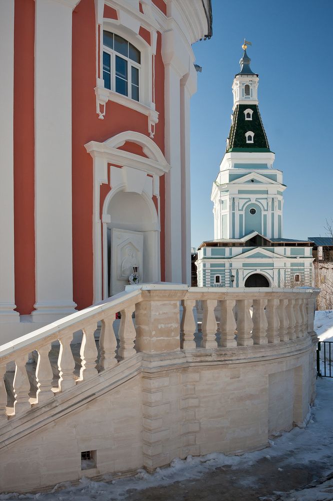 На заднем плане Каличья башня (1759 &ndash; 1772)    Каличья башня находится в северной монастырской стене, между угловой Плотничной и Звонковой башнями. Башня была сооружена заново в 1759&ndash;1772 гг. по плану архитектора И. Яковлева. Возводившаяся одновременно с колокольней, башня имеет много общего с ней в архитектурных формах и особенностях отделки ярусов. Шатровое завершение покрыто зеленой глазурованной черепицей, по примеру Троицкой башни Кремля, в 1793 г. Башня возведена над северными, Каличьими, воротами. Проезд, находящийся в воротах башни, в плане имеет глаголеобразную форму.