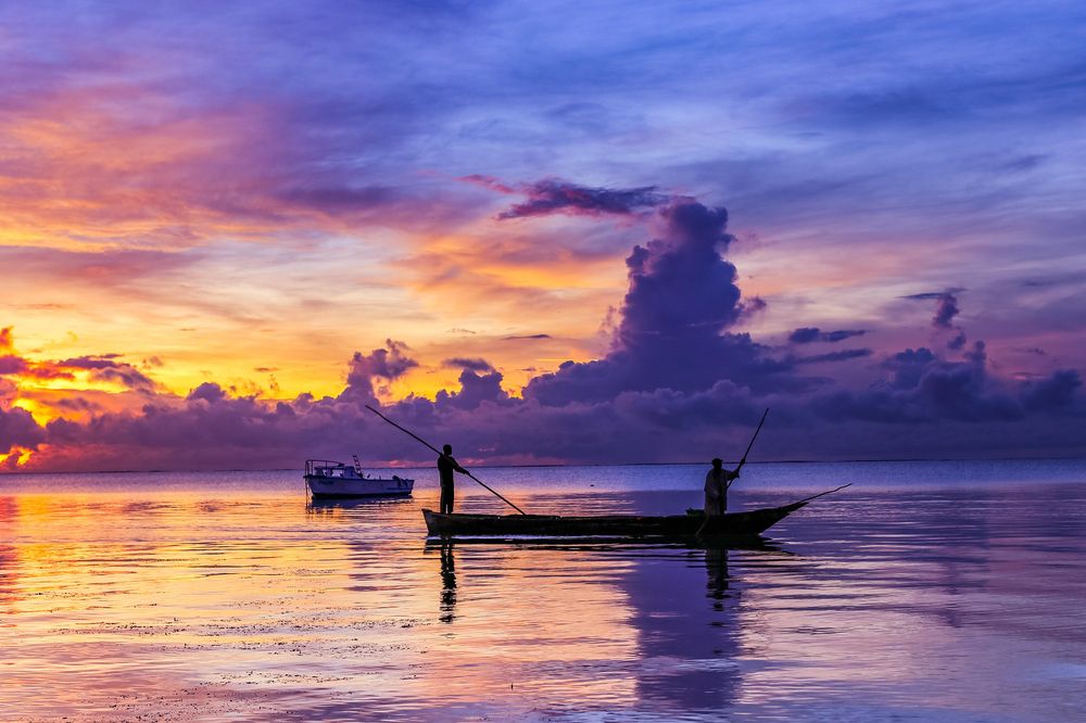 Fishermen sailing wooden boat sunrise Kenya Indian Ocean Dramatic Clouds Mombasa City County Islands