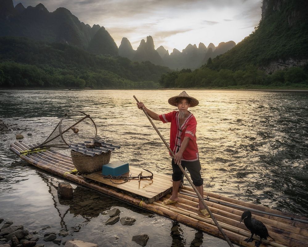 Sunset on the Lee River. A fisherman with cormorants