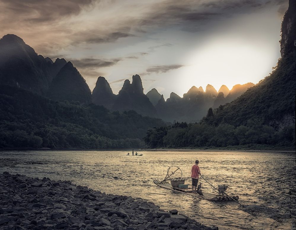 Sunset on the Lee River. A fisherman with cormorants
