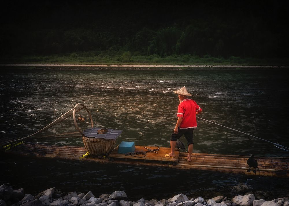 Sunset on the Lee River. A fisherman with cormorants