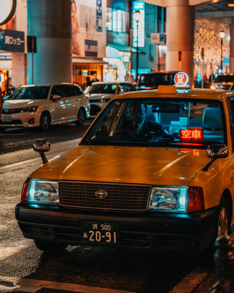 An atmospheric night shot in Dotonbori, where a traditional paper lantern and vibrant neon signs create a colorful composition.