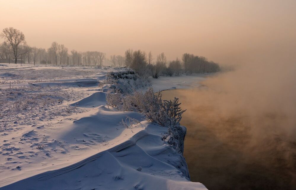Солнце светит сквозь морозную дымку, стоящую над городом.