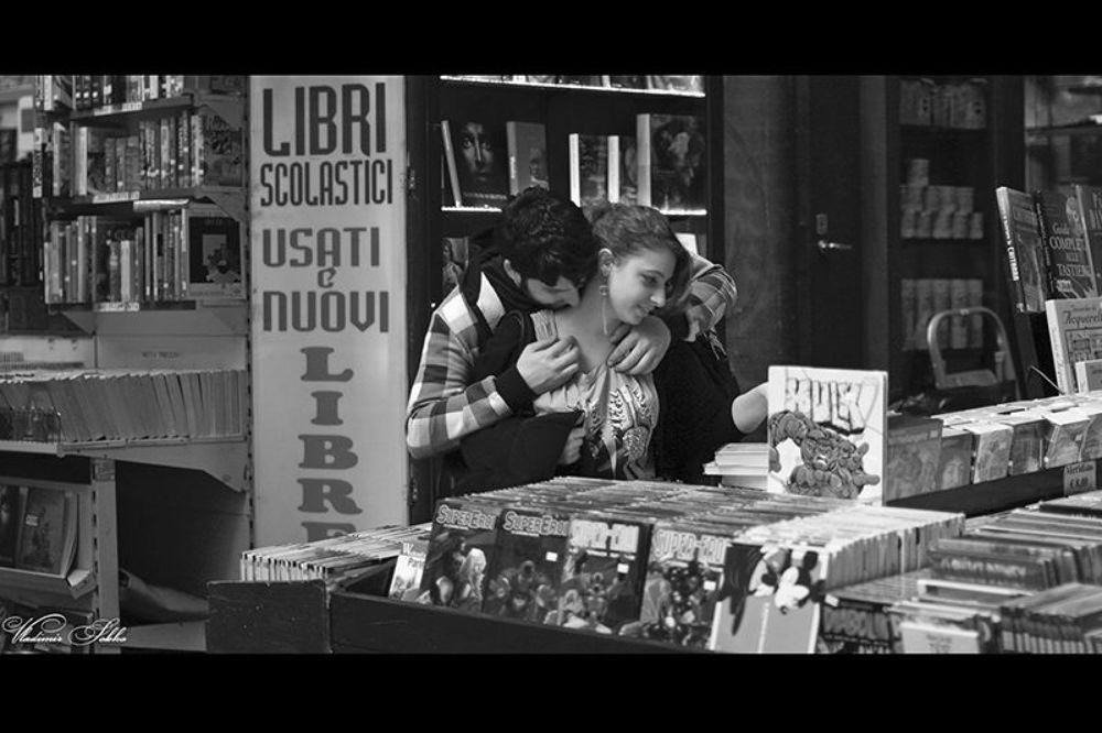 Влюбленные. Гуляя по городу увидел эту молодую пару влюбленных в книжной лавке. Пока девушка выбирала книги, парень времени не терял ))