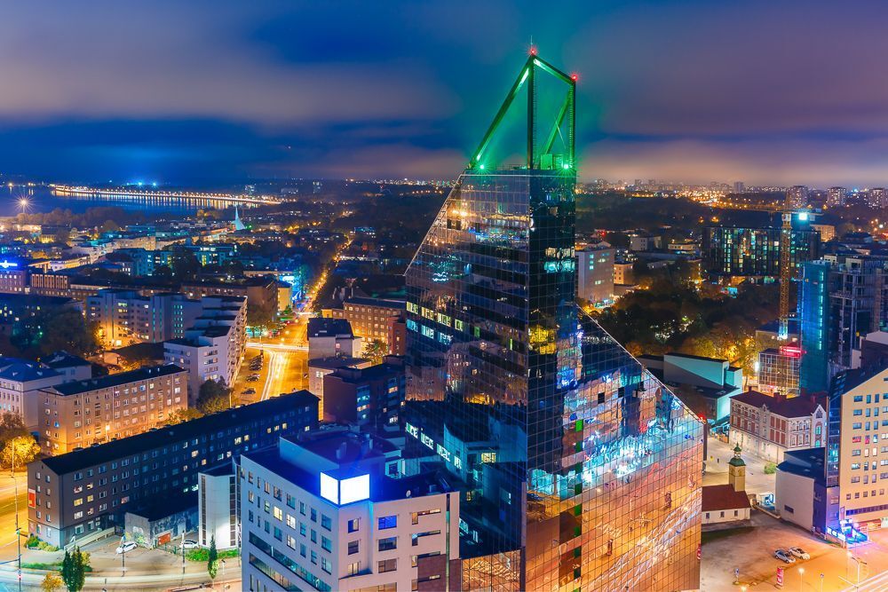 Aerial cityscape of modern business financial district with tall skyscraper buildings illuminated at night, Tallinn, Estonia
