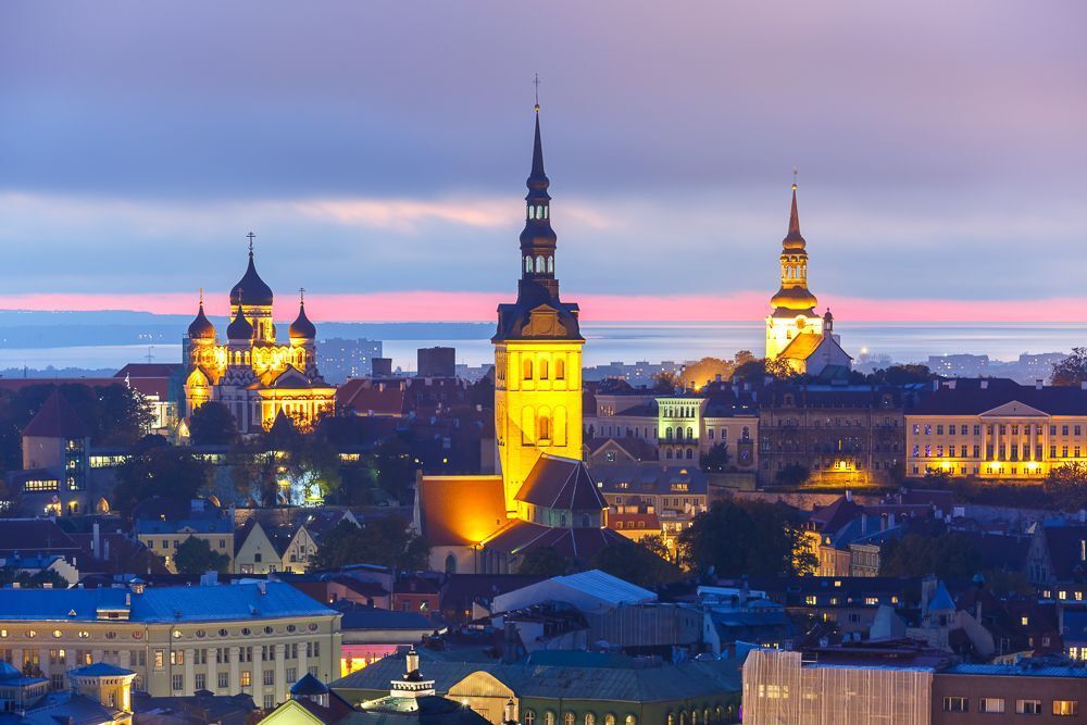 Aerial cityscape with Medieval Old Town illuminated in evening twilight with Saint Nicholas Church,  Cathedral Church of Saint Mary and Alexander Nevsky Cathedral in Tallinn, Estonia