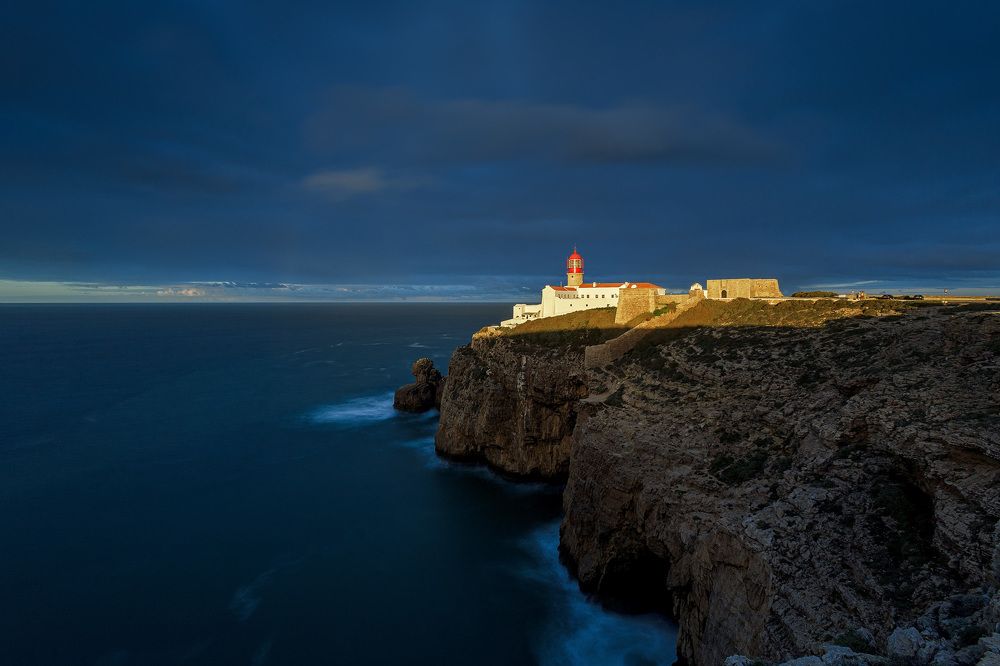 Самый мощный маяк в Европе Farol do Cabo de S&atilde;o Vicente 
в момент, когда рассветное солнце пробивается через узкую полоску на горизонте