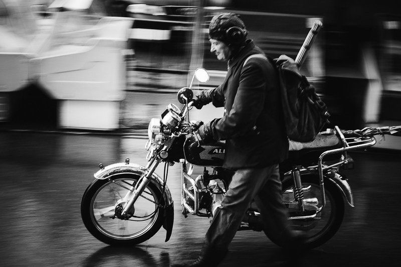 Мужчина со сломаным мотоциклом под дождем. фото превью