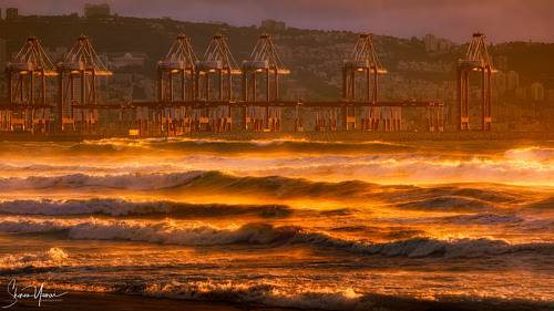 Cargo port at sunset with golden waves