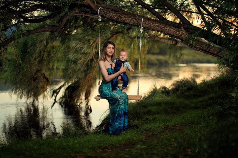 девушка с младенцем, ребёнок, вечер, дерево, шляпа, река, трава, природа, зелёный, лето, тёплый, девушка в шляпке, качель, верёвка Под ивой фото превью