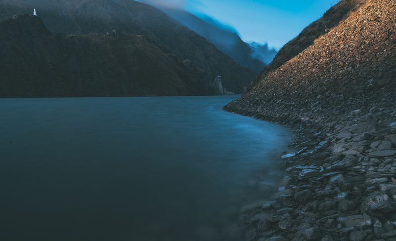 озеро, горы, камни, берег, маяк, холмы, облака, небо, дымка, выдержка, закат, пейзаж, природа Осенний закат на берегу озера. фото превью