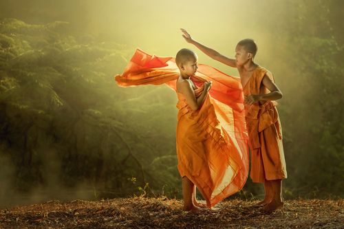 Young buddhist monk getting dressed.