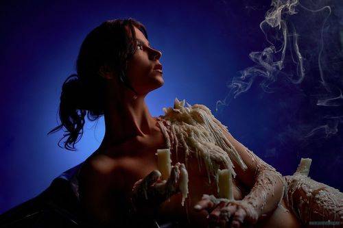 Nude lady in wax and smoke from extinguished candles 