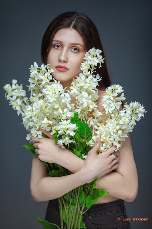 Beautiful young woman holding flowers фото превью