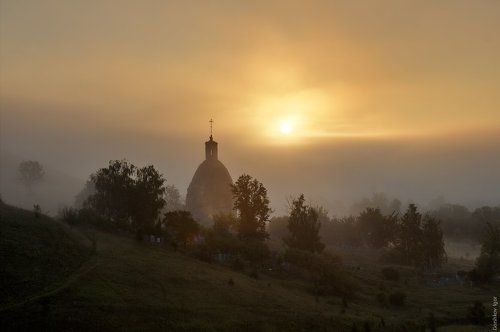 Восход солнца в тумане над разрушенной цероквью