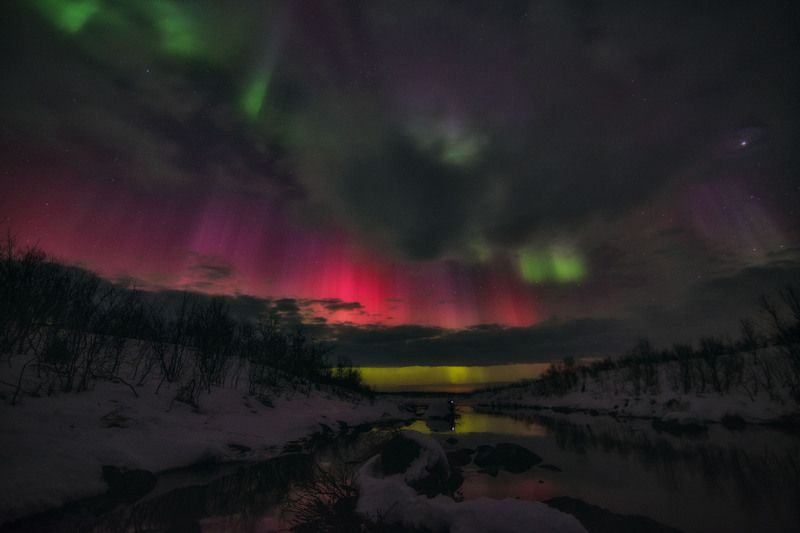 Космическое северное сияние  сквозь облака фото превью