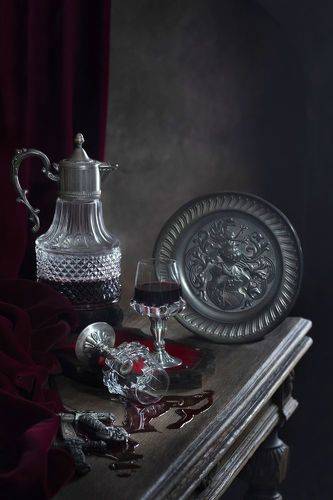 Вино разлито на столе и брошенный бокал...