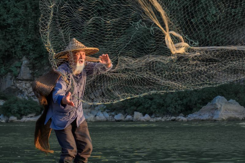 китай, мужчина, рыбак, china, fisherman, репортаж, река, рыбак с бакланом Рыбак с бакланами на реке Ли фото превью