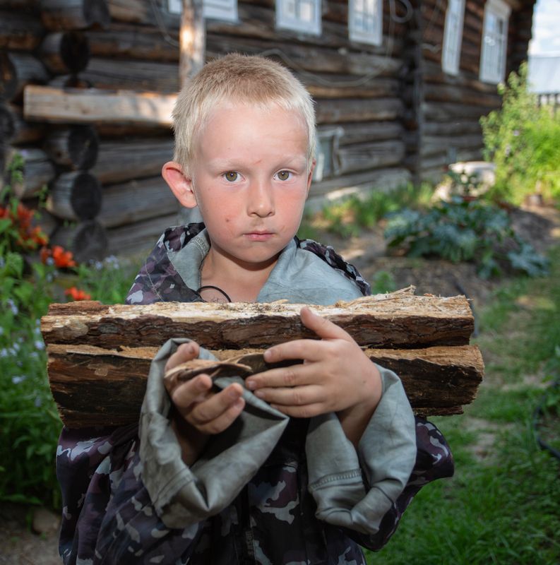 Деревенский мальчишка с дровами. фото превью