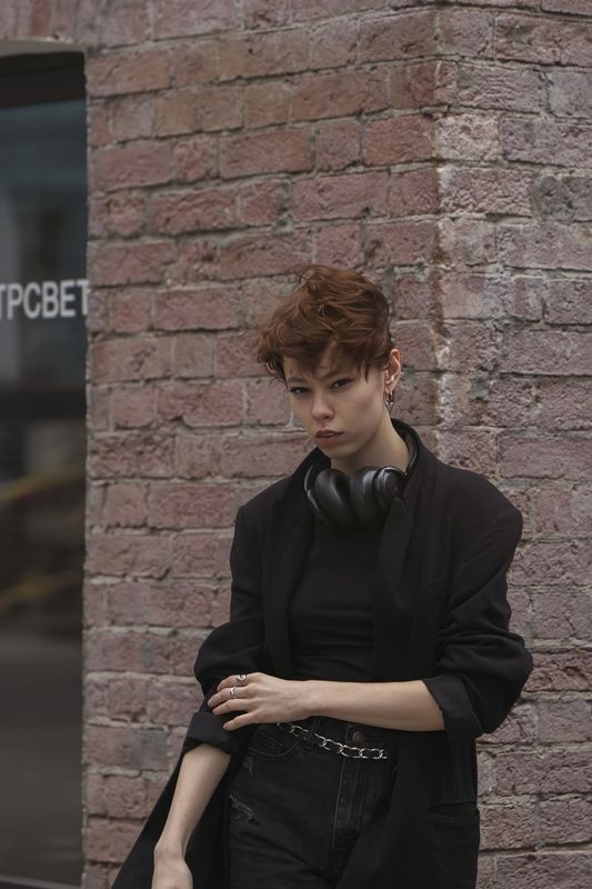 девушка, современный город, кирпичная стена, стеклянная витрина, черная одежда, шорты, наушники, лето Звуки города фото превью