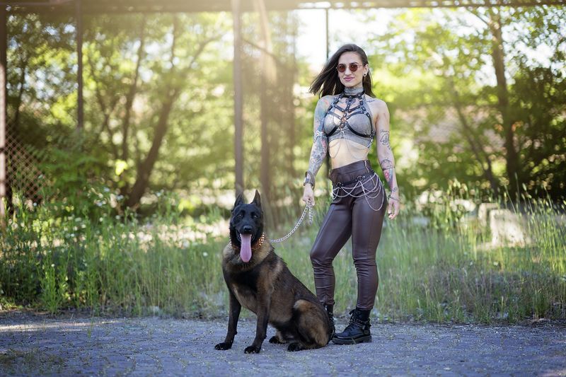 tattooed woman, Belgian Malinois, chains, alternative style, urban fashion, attitude, female power, nature-city contrast, sunlight, dominance, portrait photography, gothic style, urban forest, edgy look, outdoor fashion Urban Command фото превью