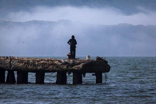 Рыбак на старом пирсе