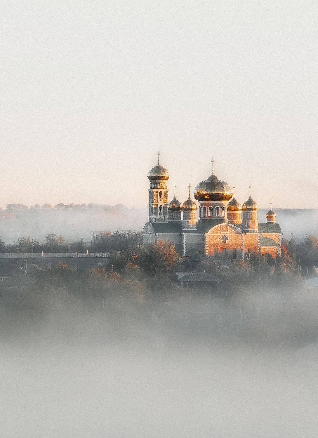 пейзаж, туман, рассвет, купола, архитектура, город, утро, мистика, кинокадр, золотой свет, монохромность (если близко), атмосферно, деревня/малый город (если применимо), силуэт, долгий фокус, минимализм, тихий город, объекты религии (но не именовать), мел, Oleg Suhenko
