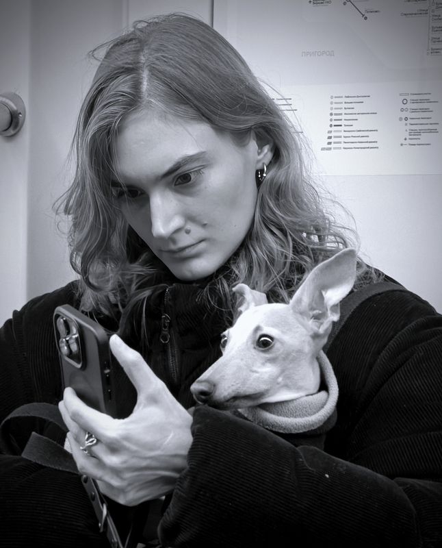 Собачка и ее хозяйка читают новости в вагоне метро. фото превью