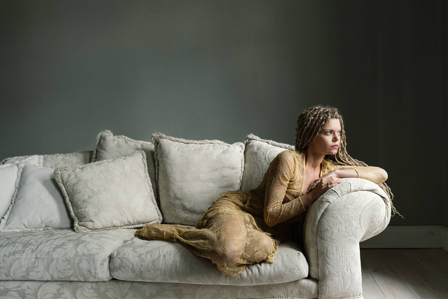 artistic portrait, braided hair, delicate fabric, elegant pose, emotional stillness, golden dress, interior minimalism, introspective gaze, muted palette, neutral d&eacute;cor, restful poise, serene composition, soft light, soft shadows, textured couch, Alex Tsarfin