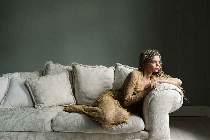 artistic portrait, braided hair, delicate fabric, elegant pose, emotional stillness, golden dress, interior minimalism, introspective gaze, muted palette, neutral décor, restful poise, serene composition, soft light, soft shadows, textured couch The Hour Between Moments фото превью