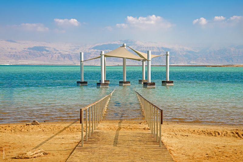 беседка; фон; пляж; красота; голубизна; мост; спокойствие; облако; облачно; побережье; береговая линия; мертвое море; месторождения; пустыня; эйн-бокек; пешеходный мост; небеса; Израиль; пейзаж; медицина; минерал; гора; природа; никого; на открытом воздух Побережье Мертвого моря. Эйн-Бокек. Израиль. фото превью