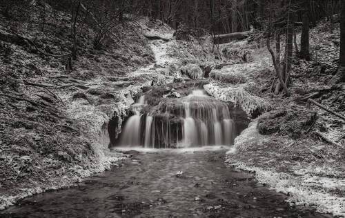 A forest river waterfall in Winter