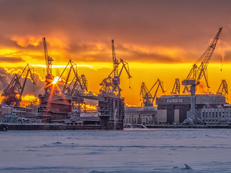 Балтийский завод в Санкт-Петербурге и Нева, освещенные зимним закатом фото превью