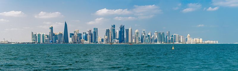 Панорама, мегаполис, столица, Катар, город, Доха, Персидскоий залива. небоскребы, вода, залив, море, дымка, голубой, современный, арабский, страны залива, облачный, небо, горизонт, широкий угол, облако, сити Панорама столицы Катара, города Доха, со стороны Персидского залива. фото превью