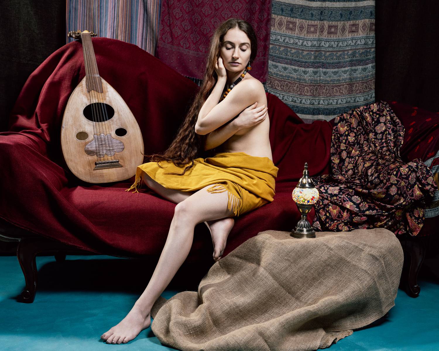 oriental portrait, studio lighting, feminine grace, traditional instrument, cultural heritage, velvet drapery, golden fabric, warm tones, contemplative mood, rich textures, introspective gaze, decorative patterns, luxurious textiles, timeless beauty, Tsarfin Alex