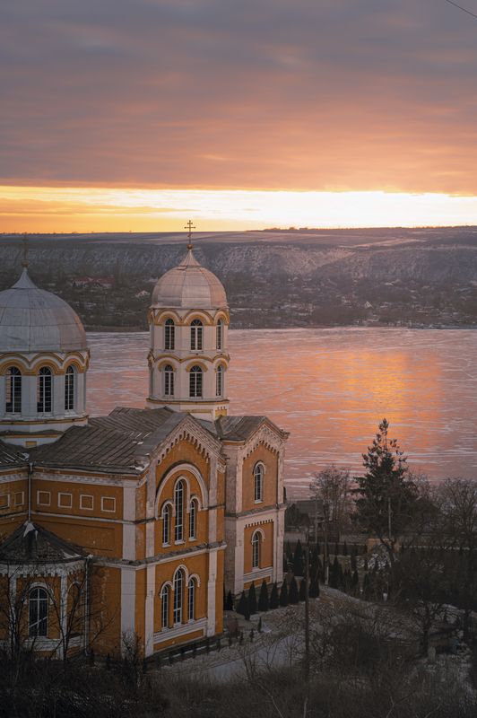 orthodox church, cathedral, winter landscape, sunset light, golden hour, frozen river, reflection, architecture, historic architecture, spirituality, silence, stillness, moody sky, pastel clouds, scenic view, hillside town, eastern europe, fine art photog Golden Silence Over the Frozen River фото превью