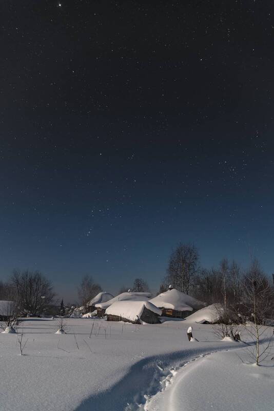 Лунная ночь в заснеженной деревне. фото превью