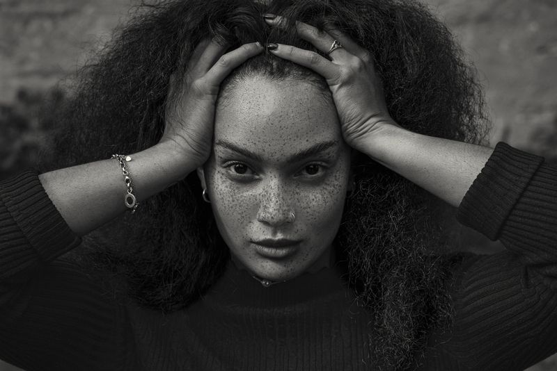 portrait photography, black and white, freckled skin, direct gaze, intense expression, emotional tension, chiaroscuro lighting, skin texture, natural hair, hands framing, female portrait, raw emotion, contemporary realism, tonal contrast, shallow depth The Architecture of Restraint фото превью