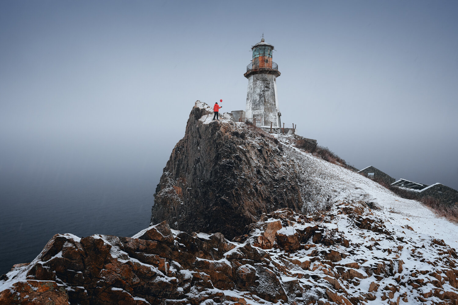 lighthouse, cliff, rocks, snow, winter, person, sea, isolated, nature, seascape, coastal, solitary figure, cold, atmospheric, moody, gray sky, rugged terrain, outdoor, пейзаж, маяк, зима, приморье, снег, Андрей
