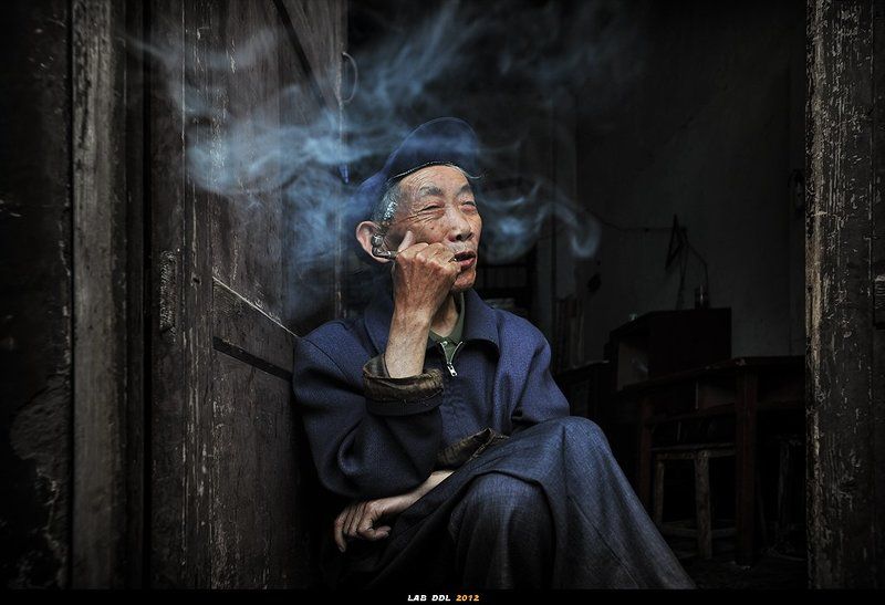 吸叶子烟的老人 фото превью