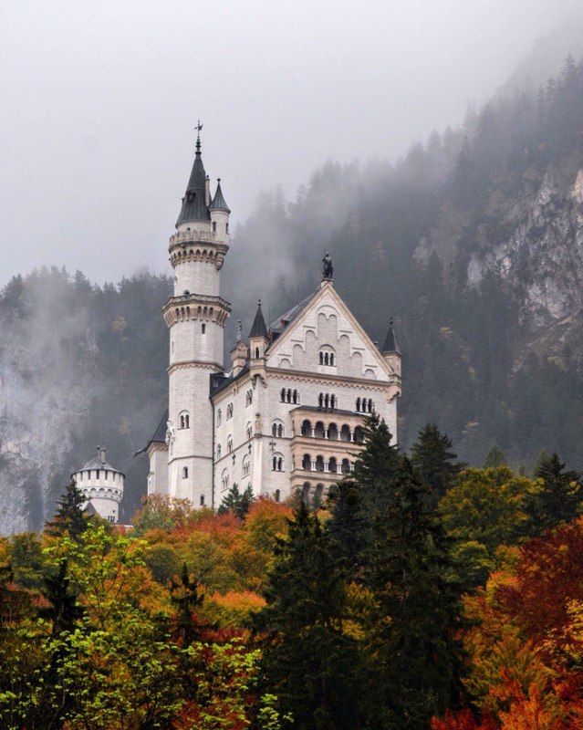 Сказочный Нойшванштайн в туманных горах, и осенних красках. фото превью
