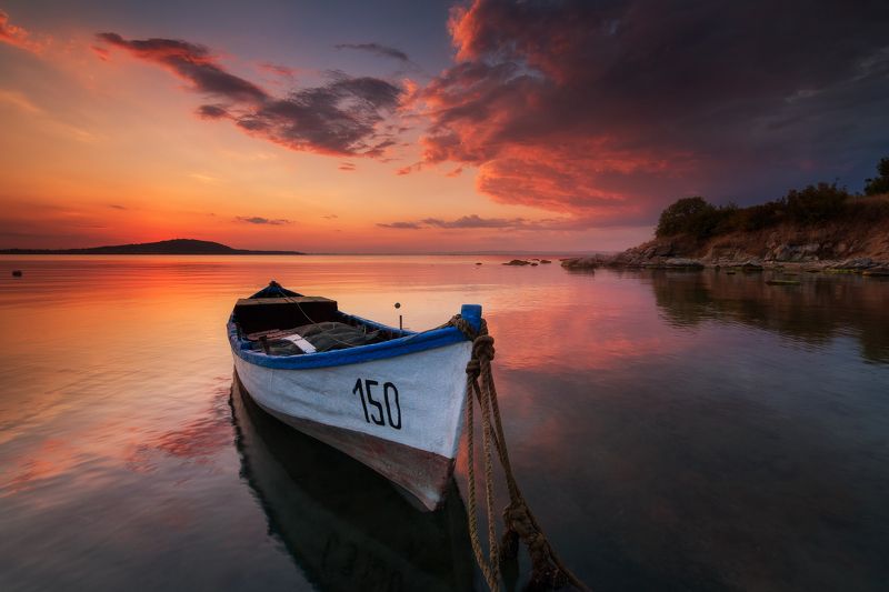 Lonely boat at sunset фото превью