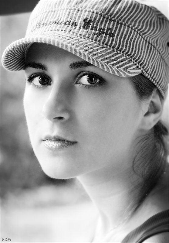 взгляд ЧБ портрет красивой девушки в кепке \