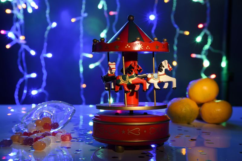 Новогодний натюрморт, карусель, деревянные лошадки, игрушечная карусель, игрушечная карусель с лошадками, Рождество, Новый год, праздник, гирлянды,мандарины, леденцы, подарки Новогодние лошадки фото превью
