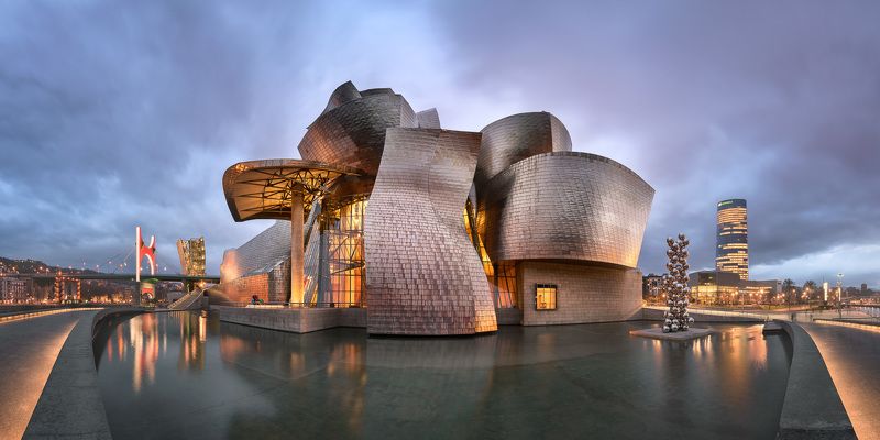 architecture, basque, bilbao, blue, bridge, building, canal, city, cityscape, country, dusk, embankment, europe, euskadi, evening, exterior, facade, guggenheim, illuminated, landmark, metal, modern, monument, museum, nevion, night, pano, panorama, pedestr Panorama of Guggenheim Museum in the Evening фото превью